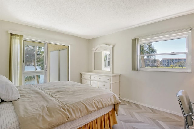 bedroom with a textured ceiling and baseboards