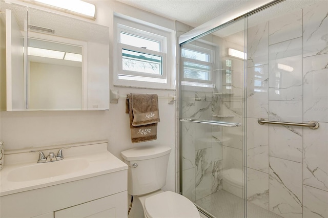 full bath featuring toilet, a marble finish shower, a textured ceiling, and vanity