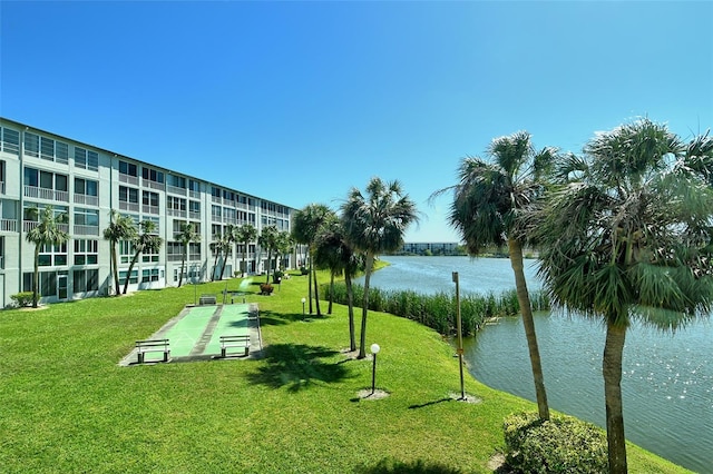 view of community featuring shuffleboard, a yard, and a water view