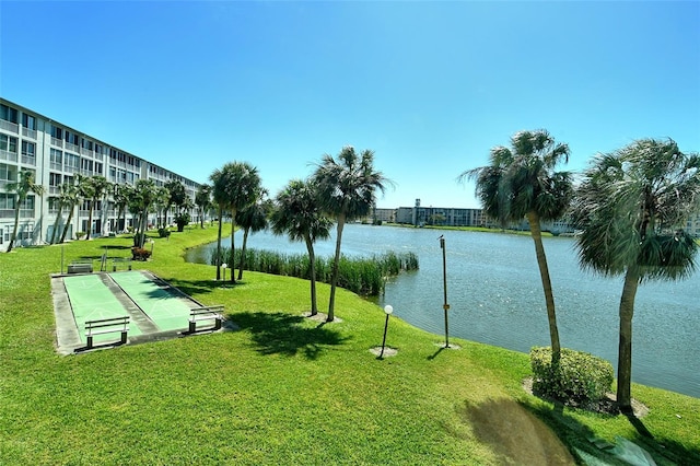 surrounding community featuring a water view, a yard, and shuffleboard