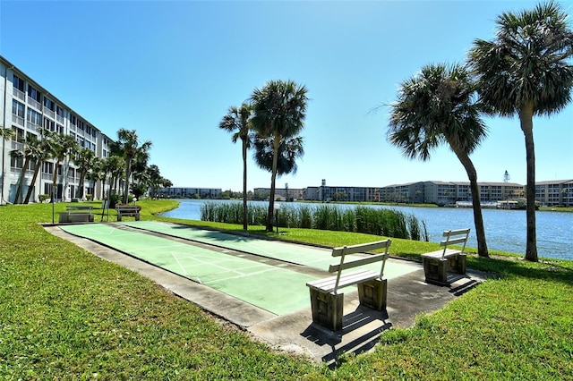 surrounding community featuring a water view, shuffleboard, and a yard