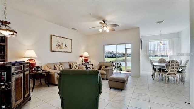 living area featuring ceiling fan and visible vents