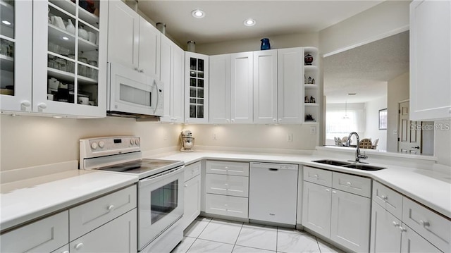 kitchen featuring recessed lighting, white appliances, a sink, white cabinets, and light countertops