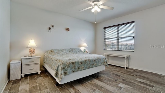 bedroom featuring wood finished floors, a ceiling fan, and baseboards