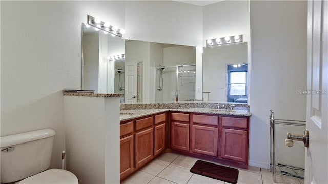 bathroom featuring tile patterned flooring, toilet, a sink, a shower stall, and double vanity