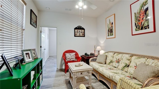 living area with visible vents, ceiling fan, and wood finished floors