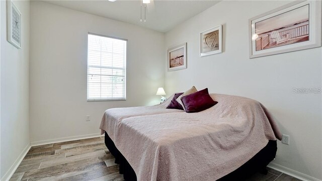 bedroom featuring wood finished floors and baseboards