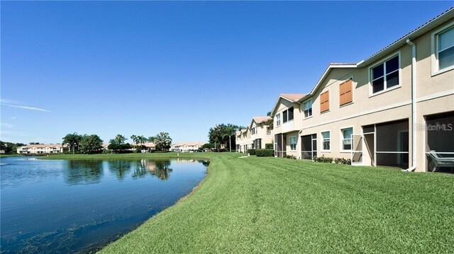 view of community with a water view, a residential view, and a lawn