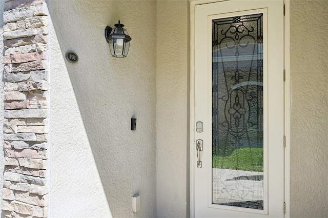 doorway to property featuring stucco siding