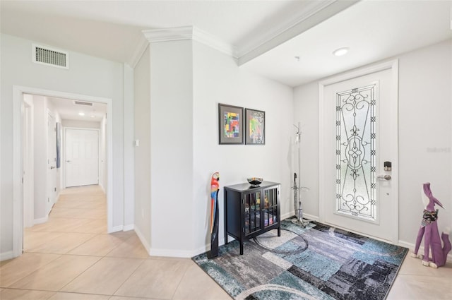 foyer with ornamental molding, visible vents, baseboards, and light tile patterned floors