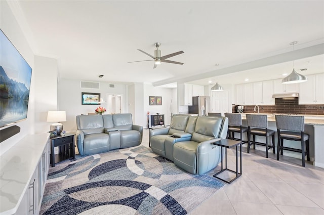 living area with light tile patterned flooring, visible vents, and a ceiling fan