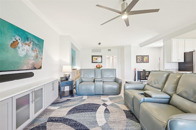 living room featuring visible vents, a ceiling fan, and light colored carpet