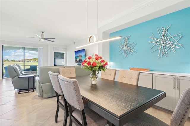 dining room with ceiling fan, light tile patterned flooring, and crown molding