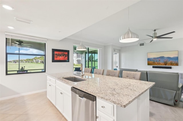 kitchen with a sink, a kitchen island with sink, light stone counters, and dishwasher