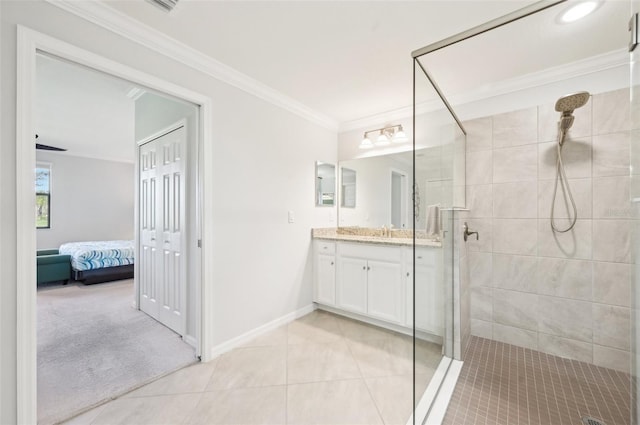 bathroom with baseboards, tile patterned floors, a tile shower, crown molding, and vanity