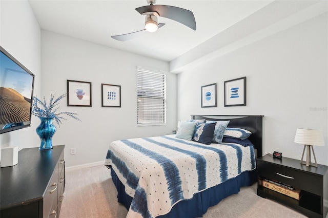 bedroom featuring a ceiling fan, light colored carpet, and baseboards