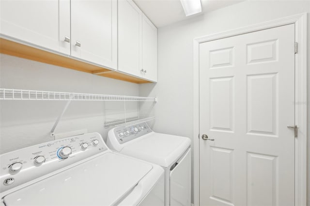 clothes washing area featuring washer and clothes dryer and cabinet space