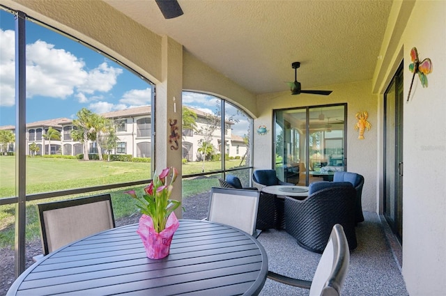 sunroom with a residential view, vaulted ceiling, and a ceiling fan