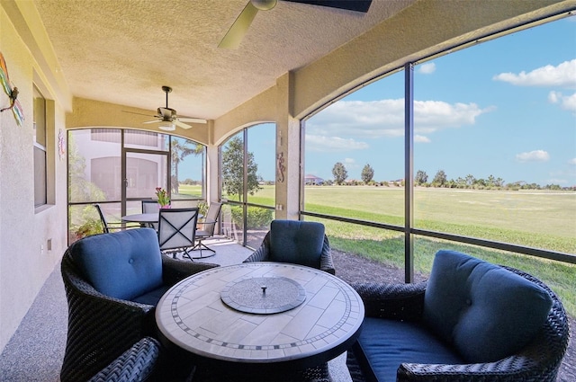 sunroom featuring plenty of natural light and a ceiling fan