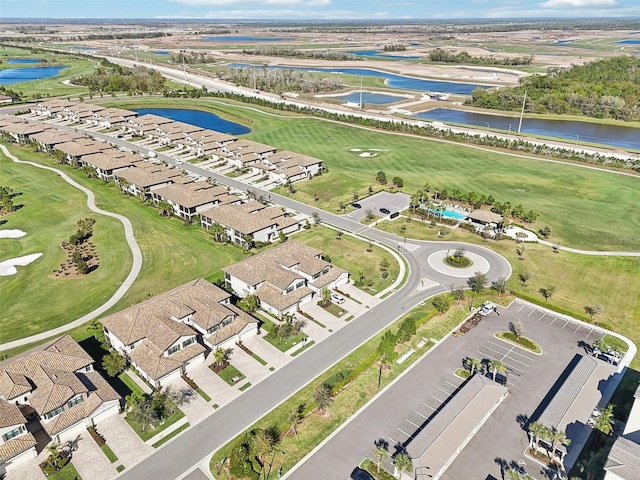 drone / aerial view with a residential view, a water view, and golf course view