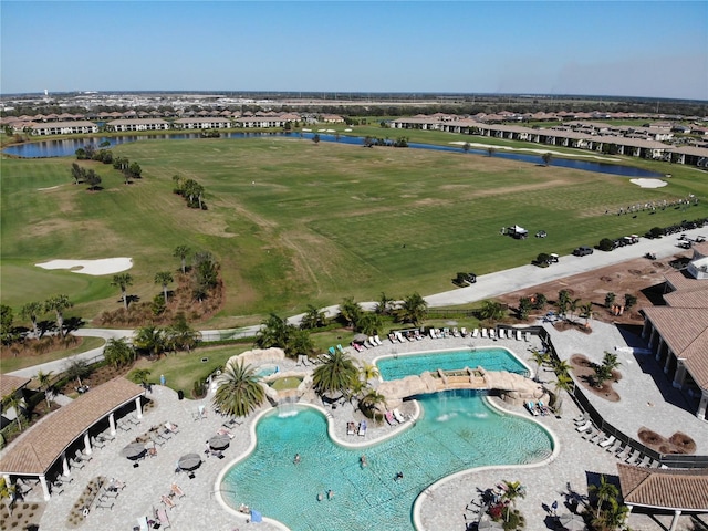 aerial view with golf course view and a water view