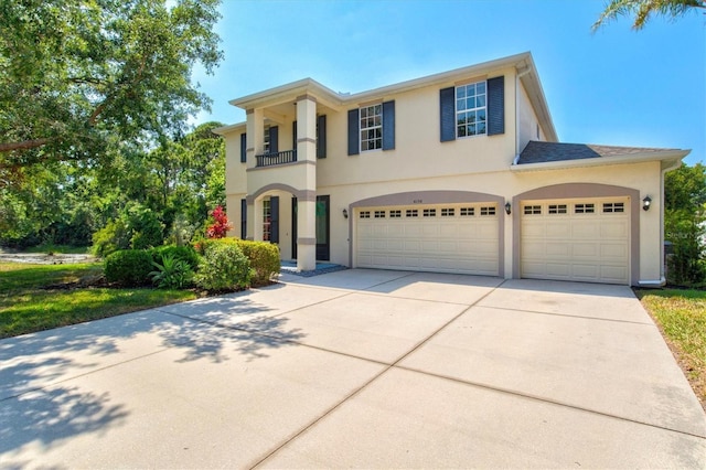 6156 41st St E, Bradenton, FL 34203 - view of front of property featuring driveway, stucco siding, an attached garage, and a balcony