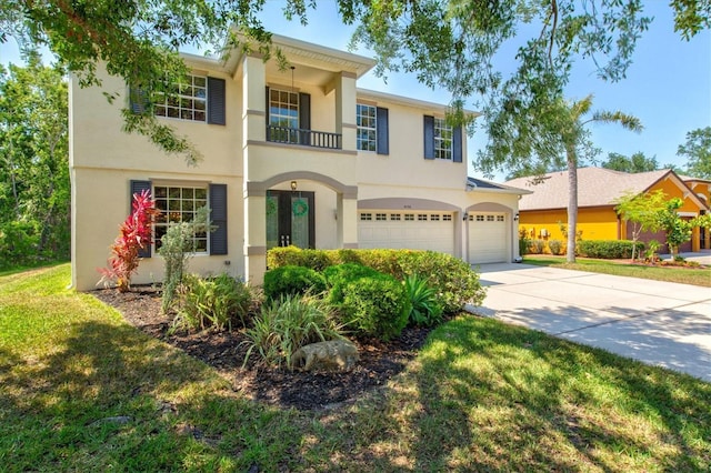 6156 41st St E, Bradenton, FL 34203 - view of front of house with a balcony, driveway, stucco siding, a garage, and a front lawn