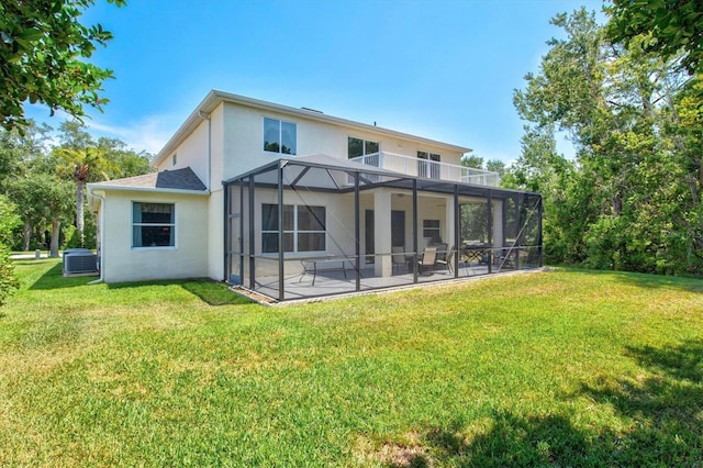 6156 41st St E, Bradenton, FL 34203 - back of property featuring stucco siding, a lawn, glass enclosure, and a patio area