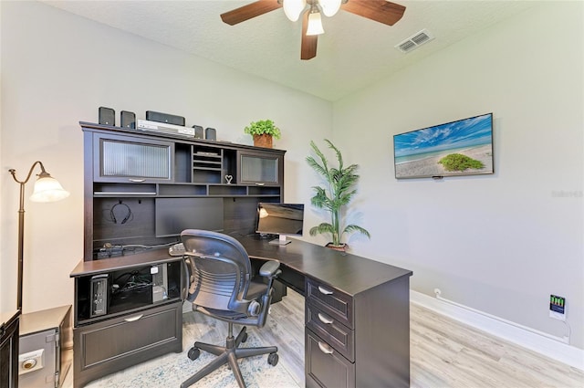 office space with visible vents, a ceiling fan, a textured ceiling, light wood-type flooring, and baseboards