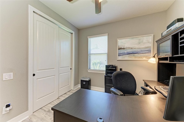 office area featuring ceiling fan, light wood-style flooring, and baseboards