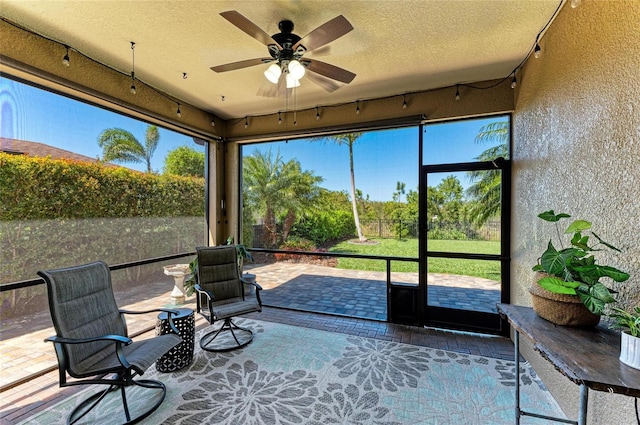 unfurnished sunroom featuring plenty of natural light and a ceiling fan