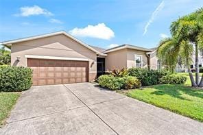 ranch-style house featuring a front lawn, an attached garage, and driveway