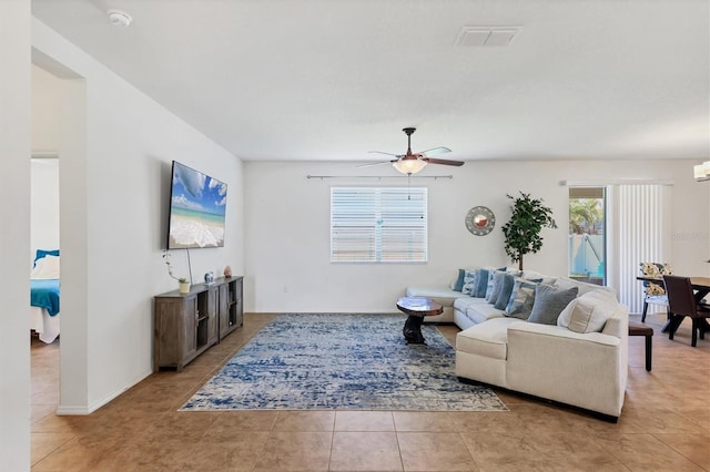 living room with visible vents, light tile patterned flooring, and ceiling fan