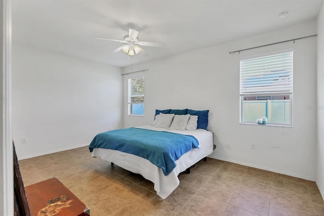 bedroom with baseboards, tile patterned flooring, and a ceiling fan