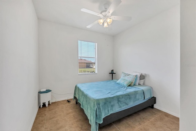 tiled bedroom featuring baseboards and a ceiling fan