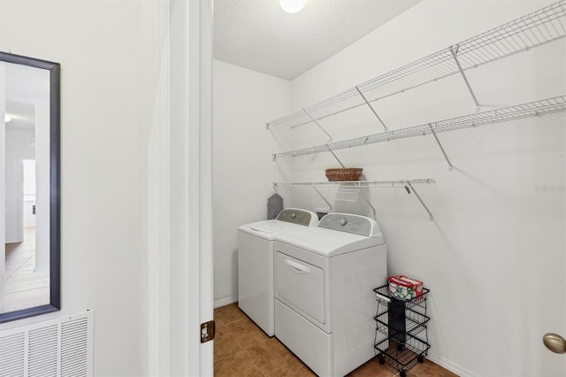 laundry area with baseboards, washer and dryer, light tile patterned flooring, visible vents, and laundry area