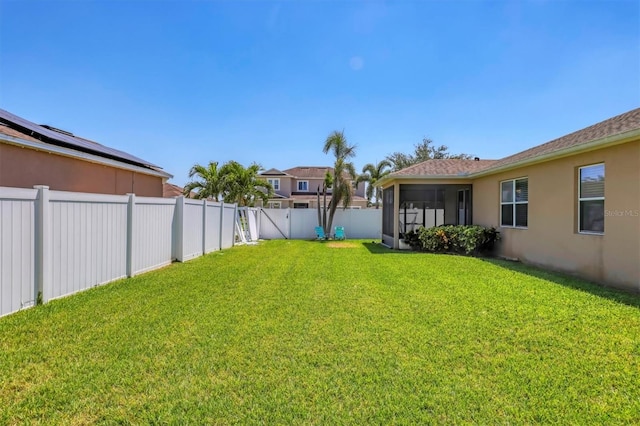 view of yard featuring a sunroom and a fenced backyard