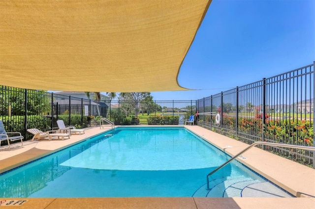 community pool with a patio and fence