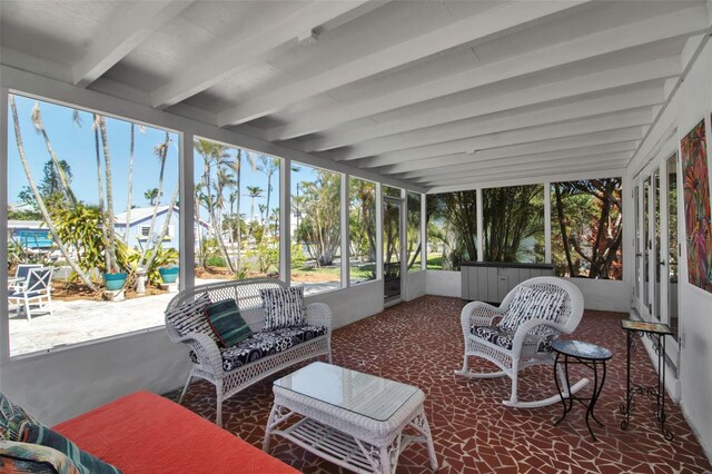 sunroom / solarium featuring beamed ceiling