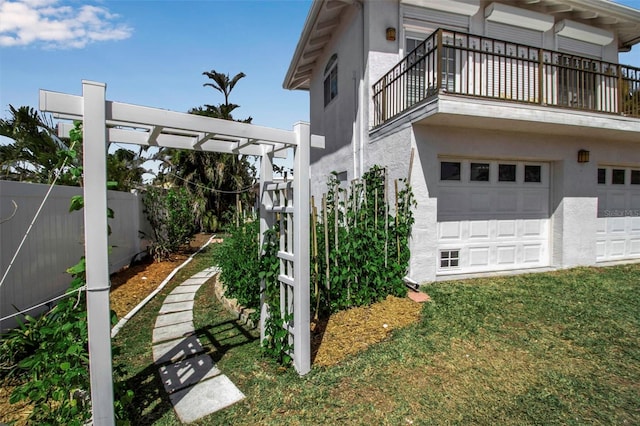 view of home's exterior featuring a pergola, fence, a balcony, and stucco siding