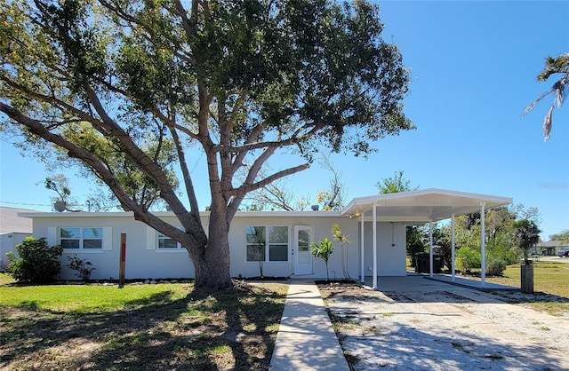 view of front of house with driveway, a front lawn, and a carport