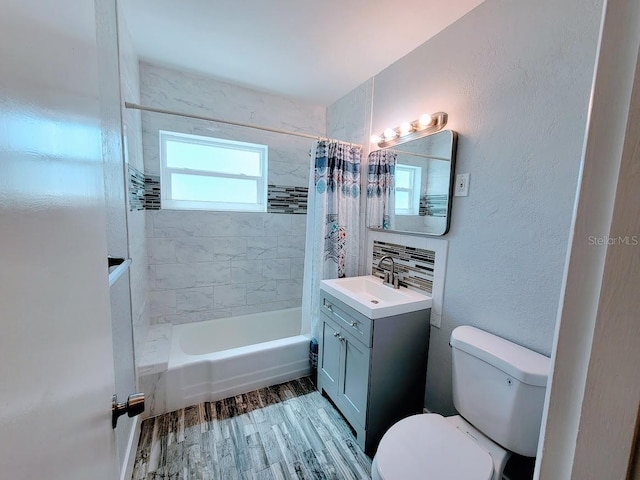 full bathroom featuring toilet, wood finished floors, vanity, decorative backsplash, and shower / bath combo