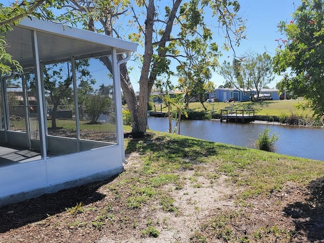 view of yard featuring a water view and a sunroom