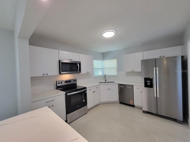 kitchen featuring stainless steel appliances, a sink, light countertops, and white cabinetry