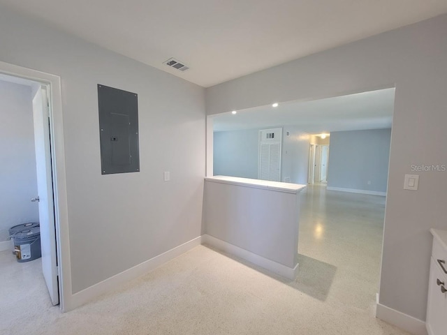 spare room featuring baseboards, electric panel, and visible vents