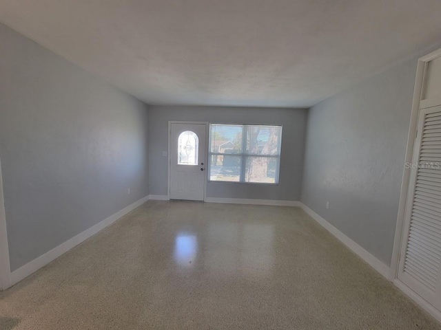 entrance foyer featuring light speckled floor and baseboards