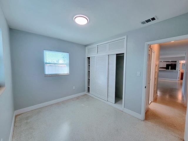 unfurnished bedroom with speckled floor, a closet, visible vents, and baseboards