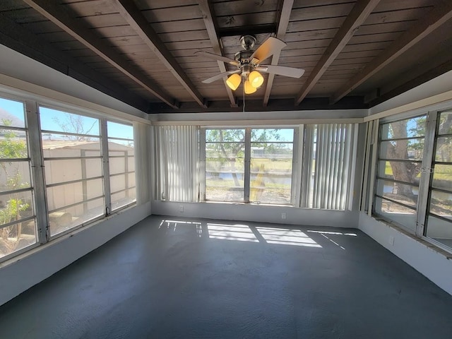 unfurnished sunroom featuring ceiling fan, beamed ceiling, and plenty of natural light