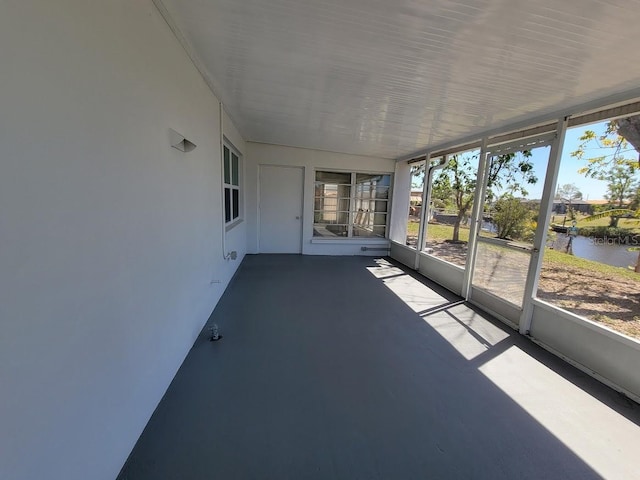 unfurnished sunroom featuring a water view