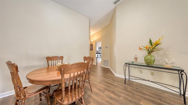 dining room with high vaulted ceiling, wood finished floors, visible vents, and baseboards